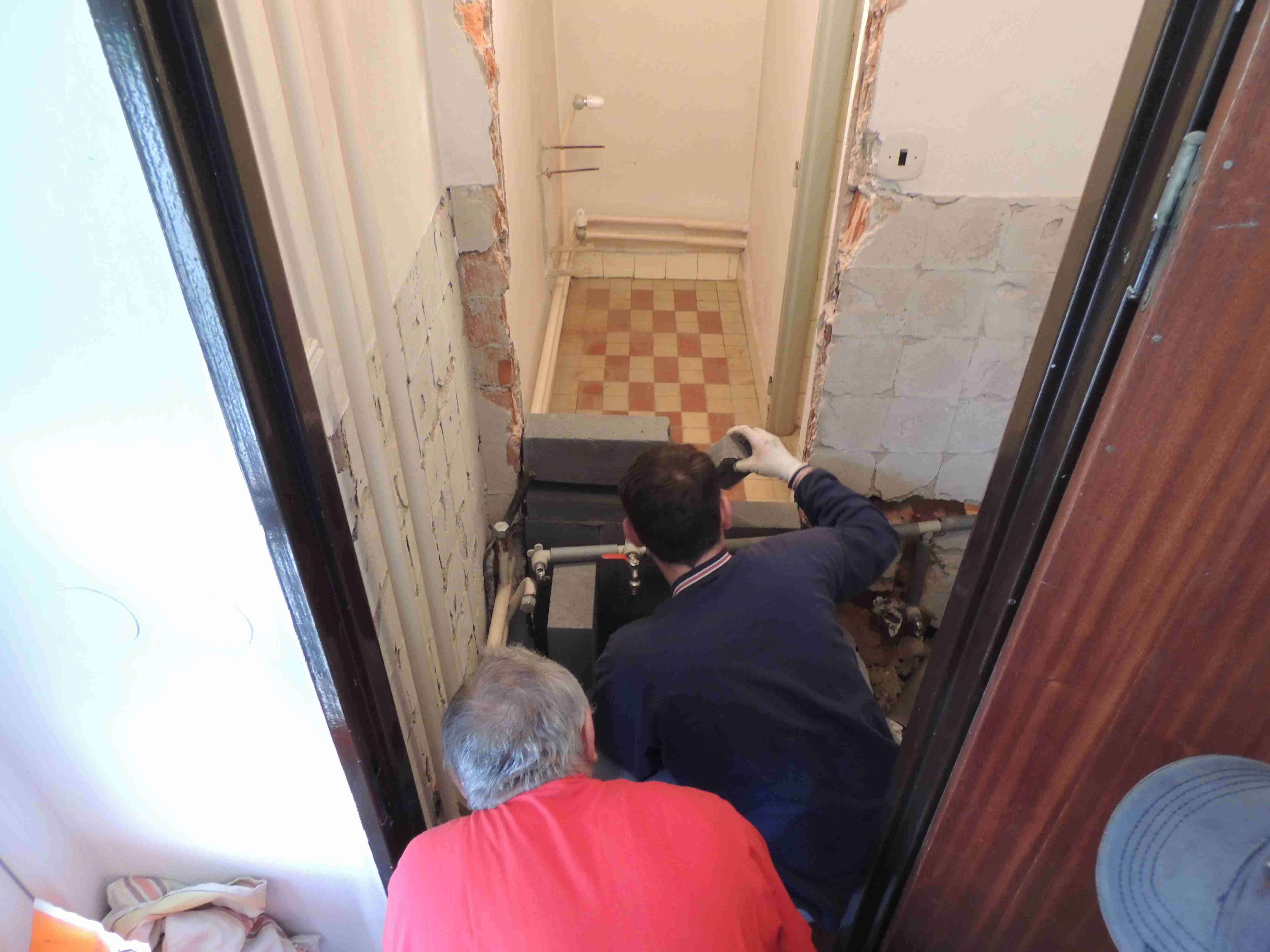 Br. farár Krivuš a br. Rusnák murujú priečku novej toalety